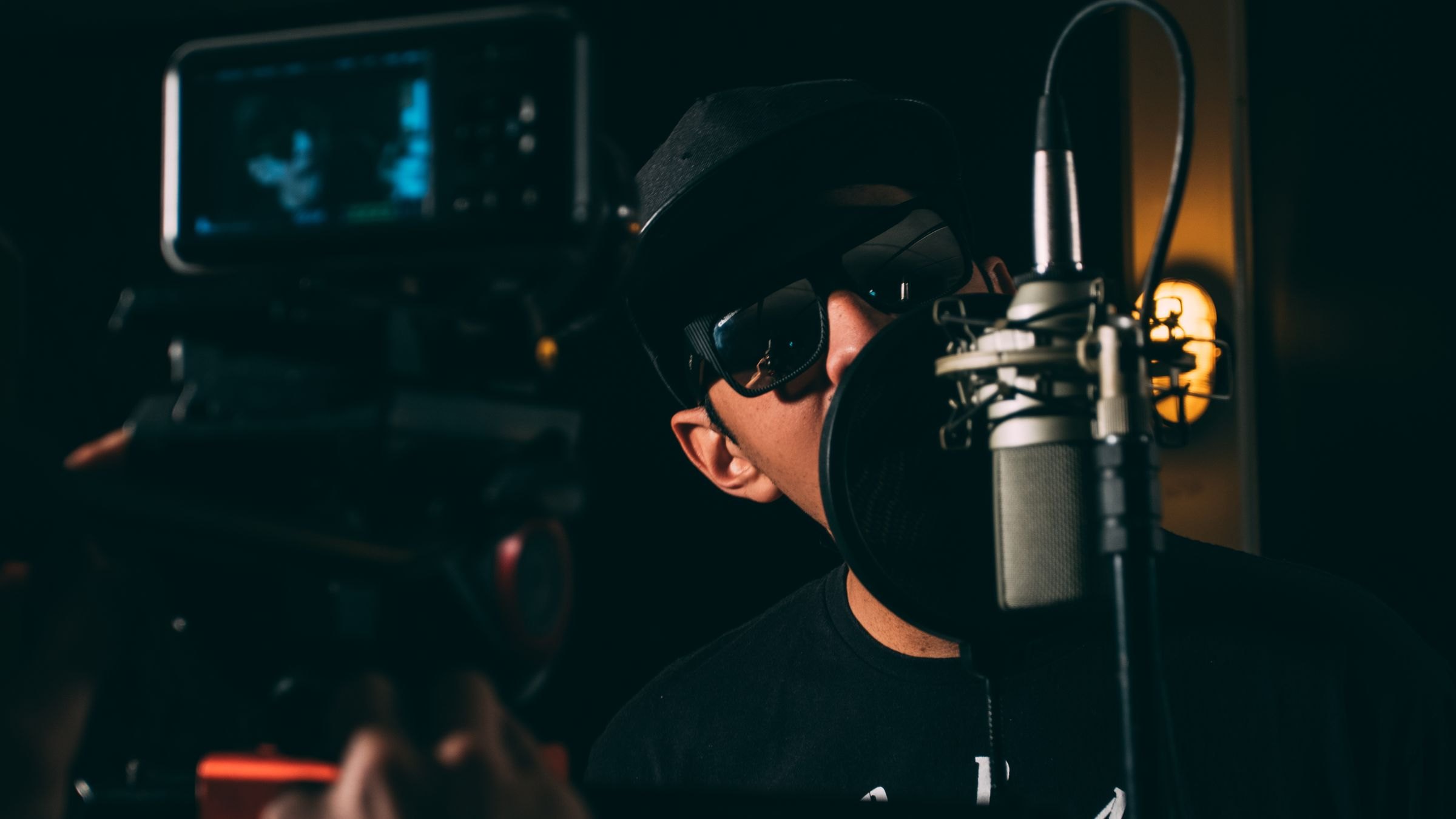 Rapper nimmt im dunklen Studio am Mikrofon auf